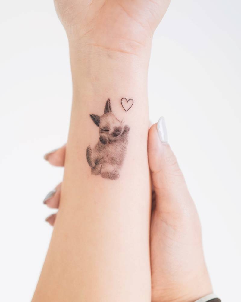 Cute bunny tattoo in micro-realistic style located on the wrist.