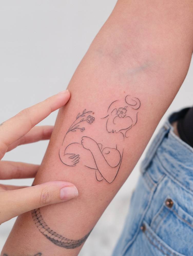 Fine line style motherhood tattoo located on the inner forearm.