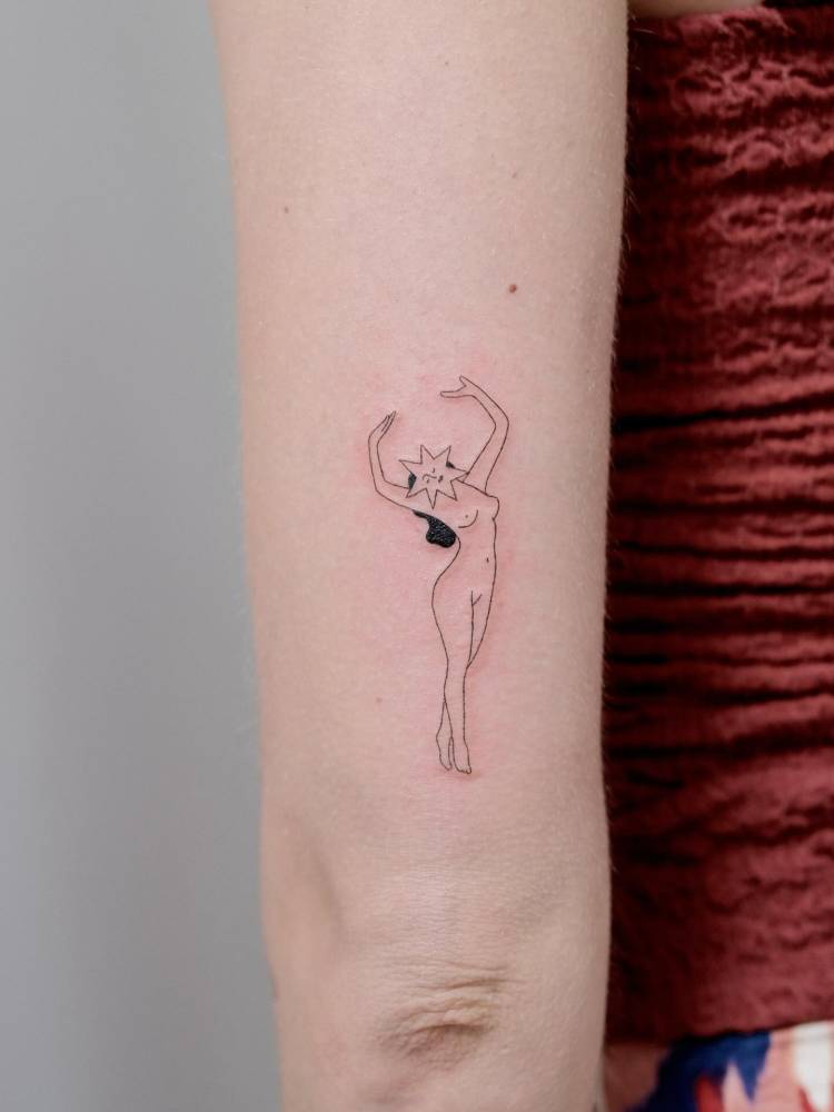 Fine line style nude woman tattoo located on the tricep.
