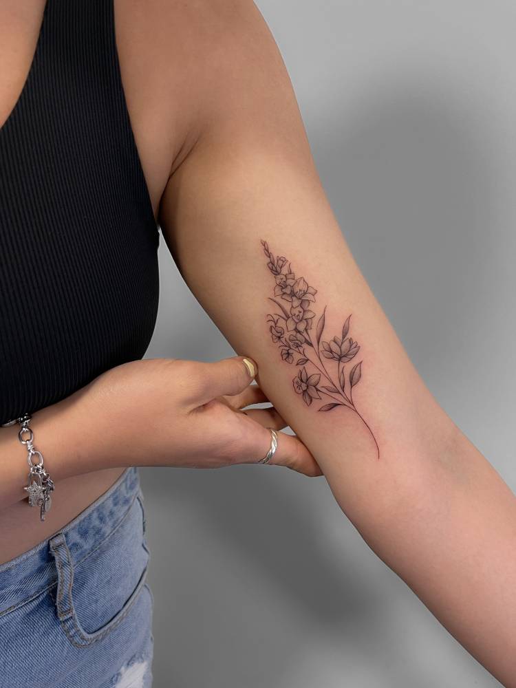 Flower bouquet tattoo in illustrative style placed on the inner arm.