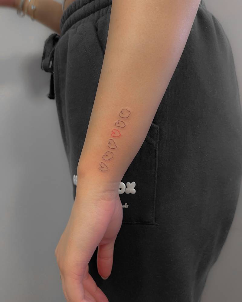 Little hearts drawn by a child tattooed on the wrist.