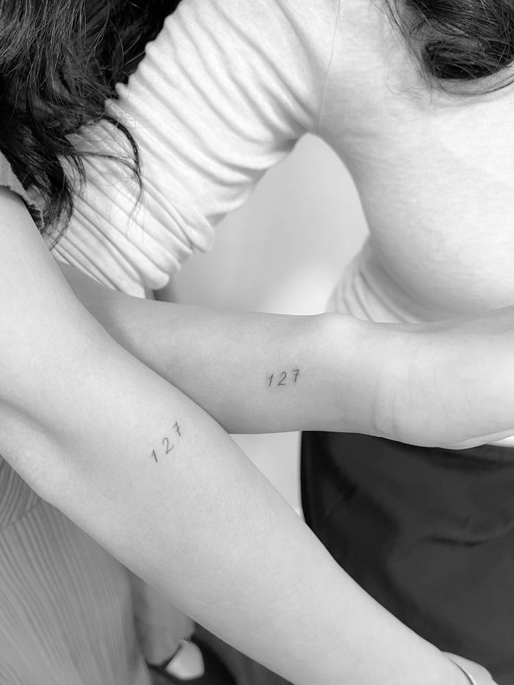 Matching tattoo of the number "127" for best friends.