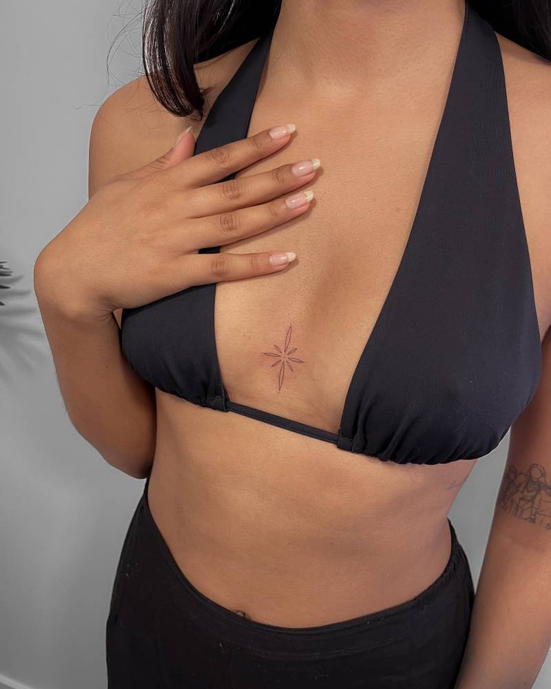 North star tattoo in fine line style placed on the sternum.