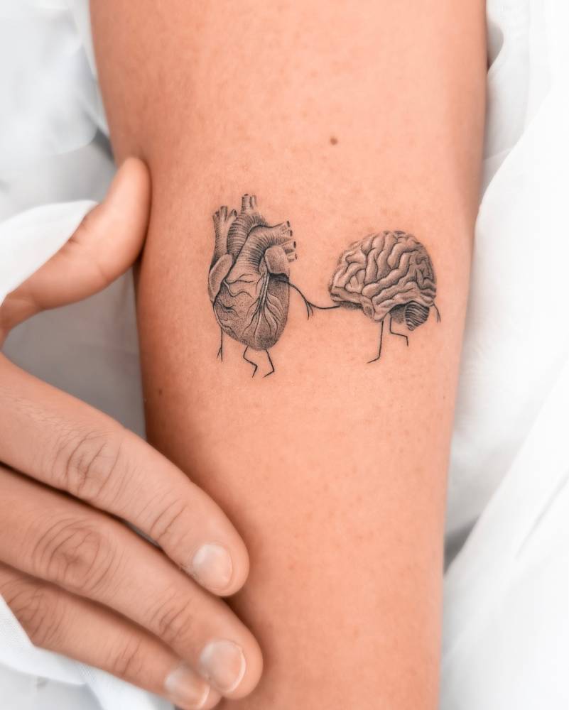 Heart vs. brain tattoo located on the forearm.