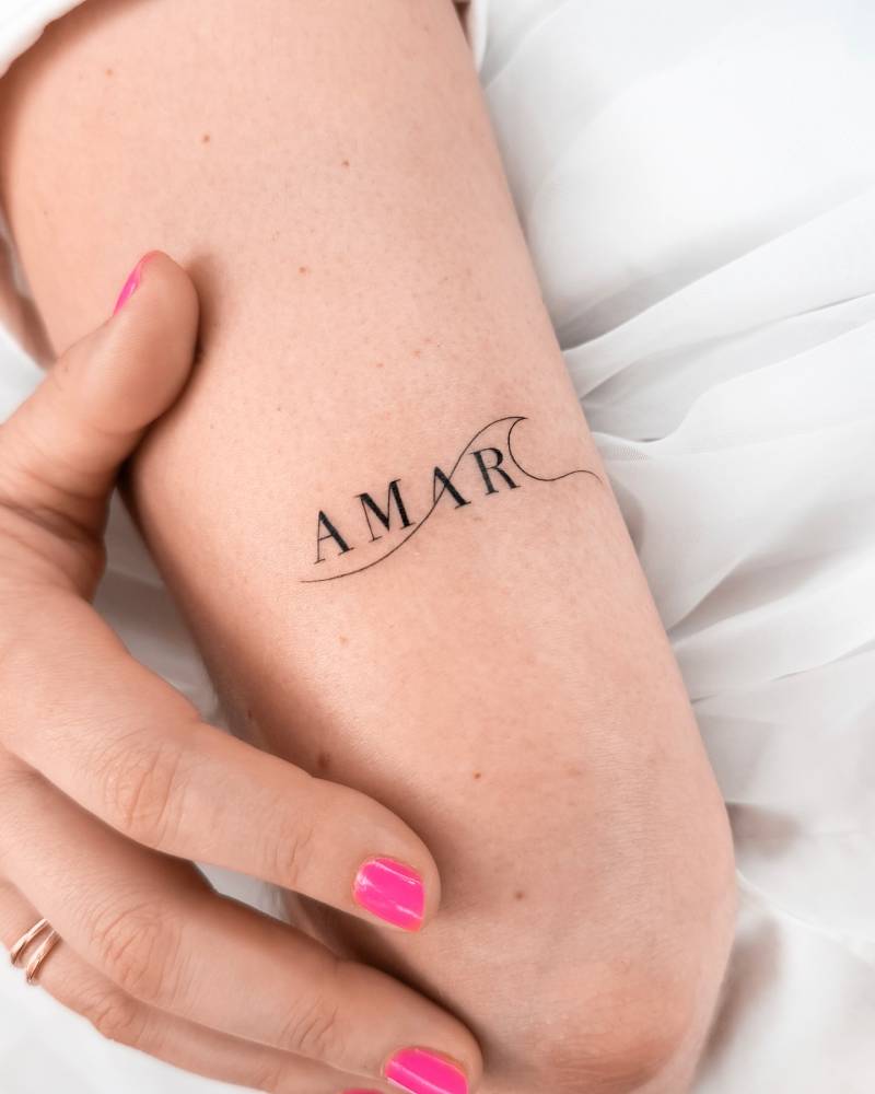 Word "amar" and wave tattoo located on the tricep.