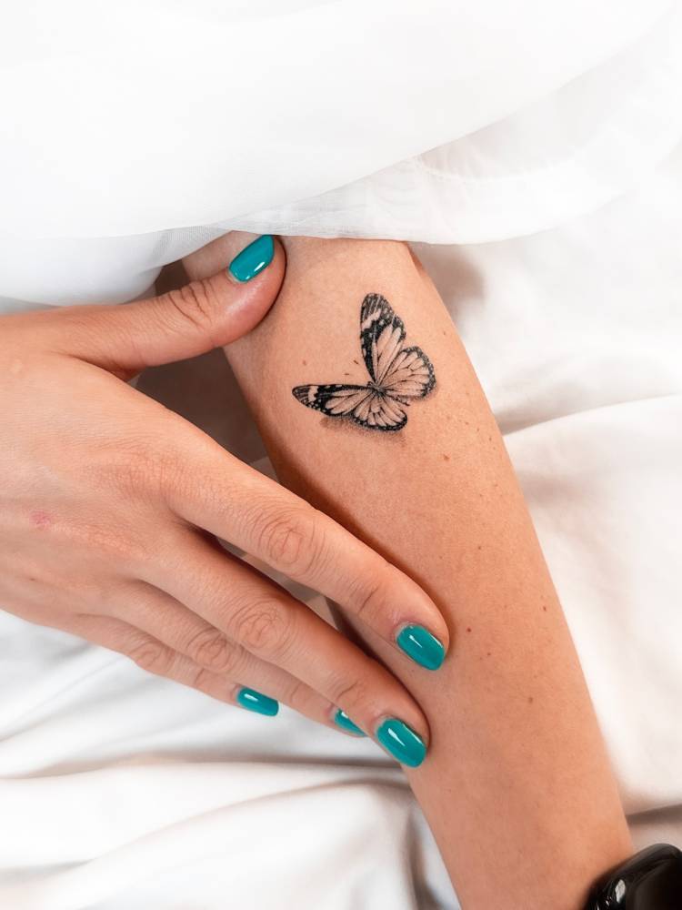 3d effect butterfly tattoo located on the forearm, micro-realistic style.