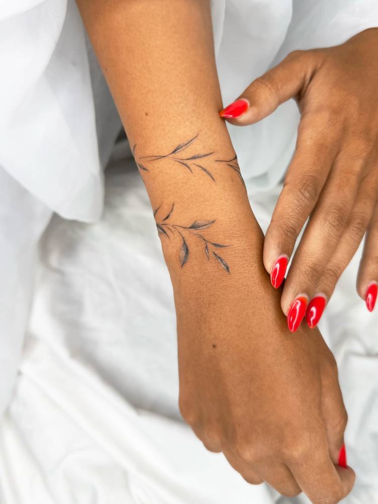 Leaves bracelet tattoo located on the wrist, illustrative style.