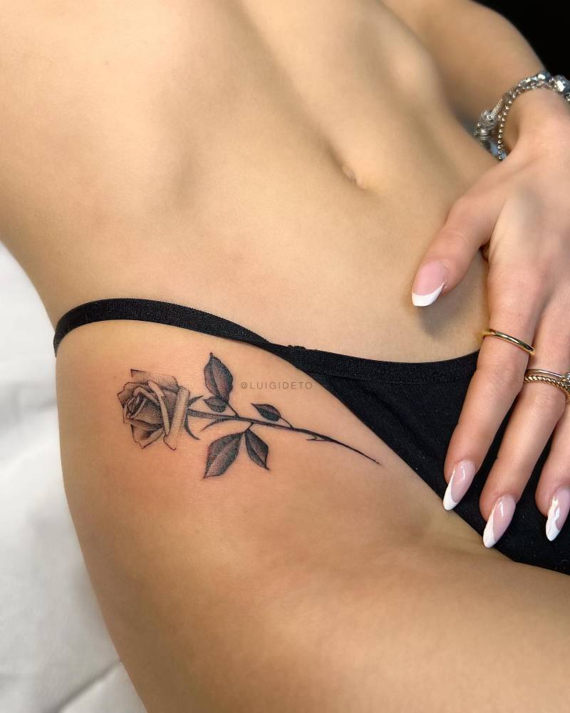 Illustrative style rose tattoo placed on the pelvis.