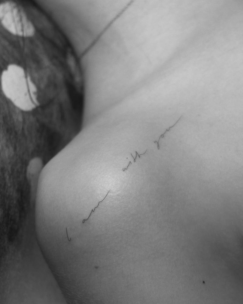 "I am with you" handwritten lettering tattoo located on the shoulder.