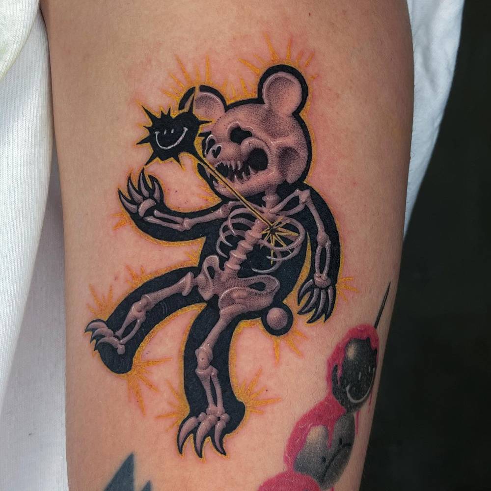 Teddy bear x-ray tattoo located on the upper arm.