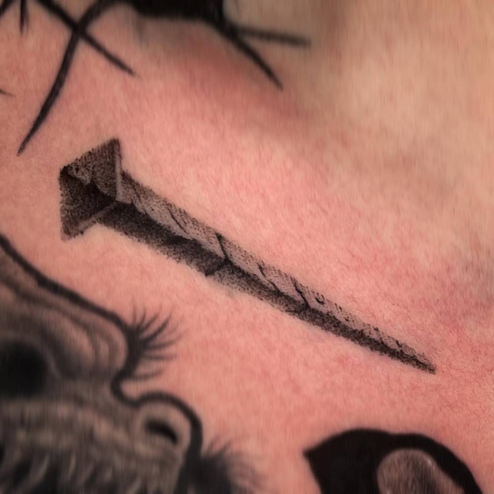 Dotwork style nail tattoo located on the collarbone.