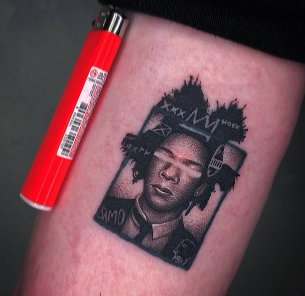 Basquiat portrait tattoo located on the upper arm.