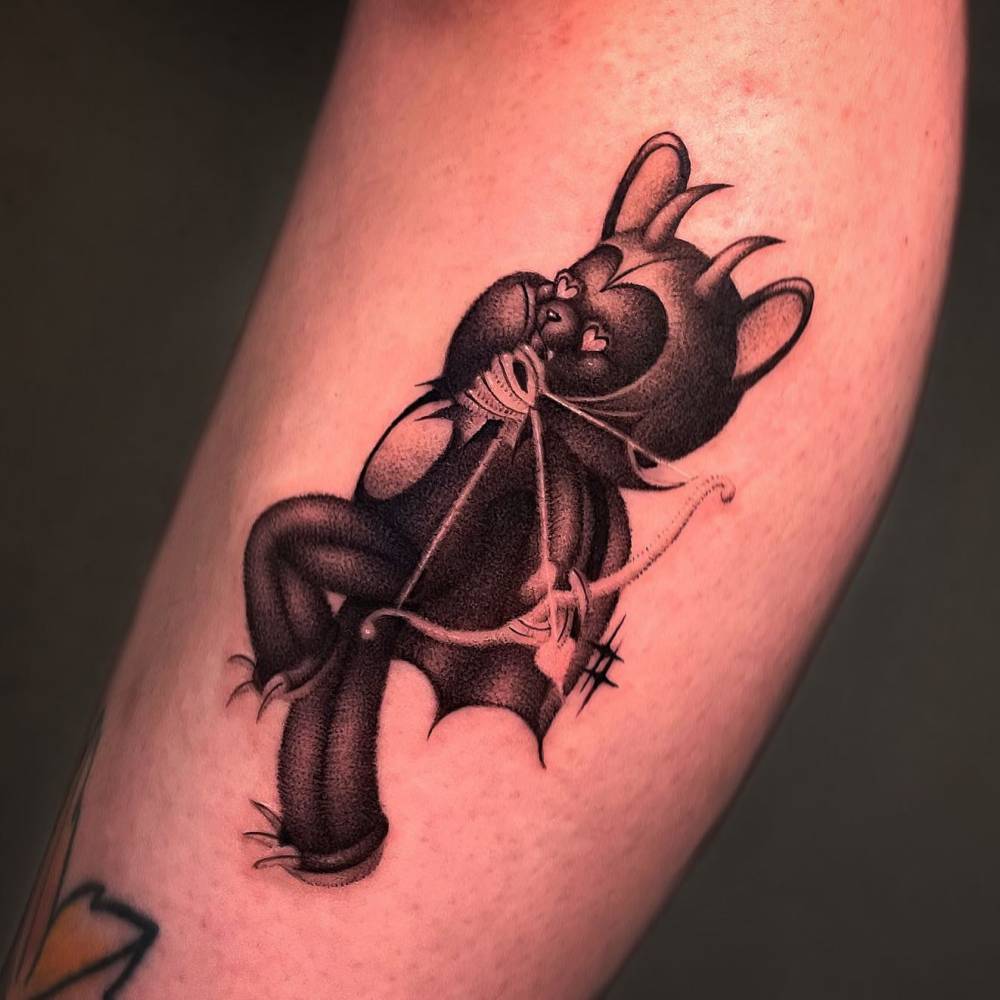Devil teddy bear tattoo located on the shin.