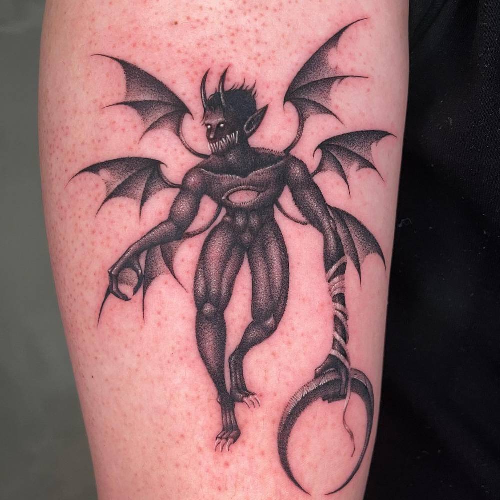 Devil tattoo in dotwork style placed on the upper arm.