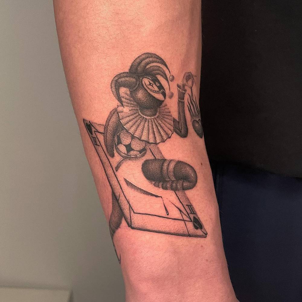 Joker tattoo in blackwork style located on the forearm.