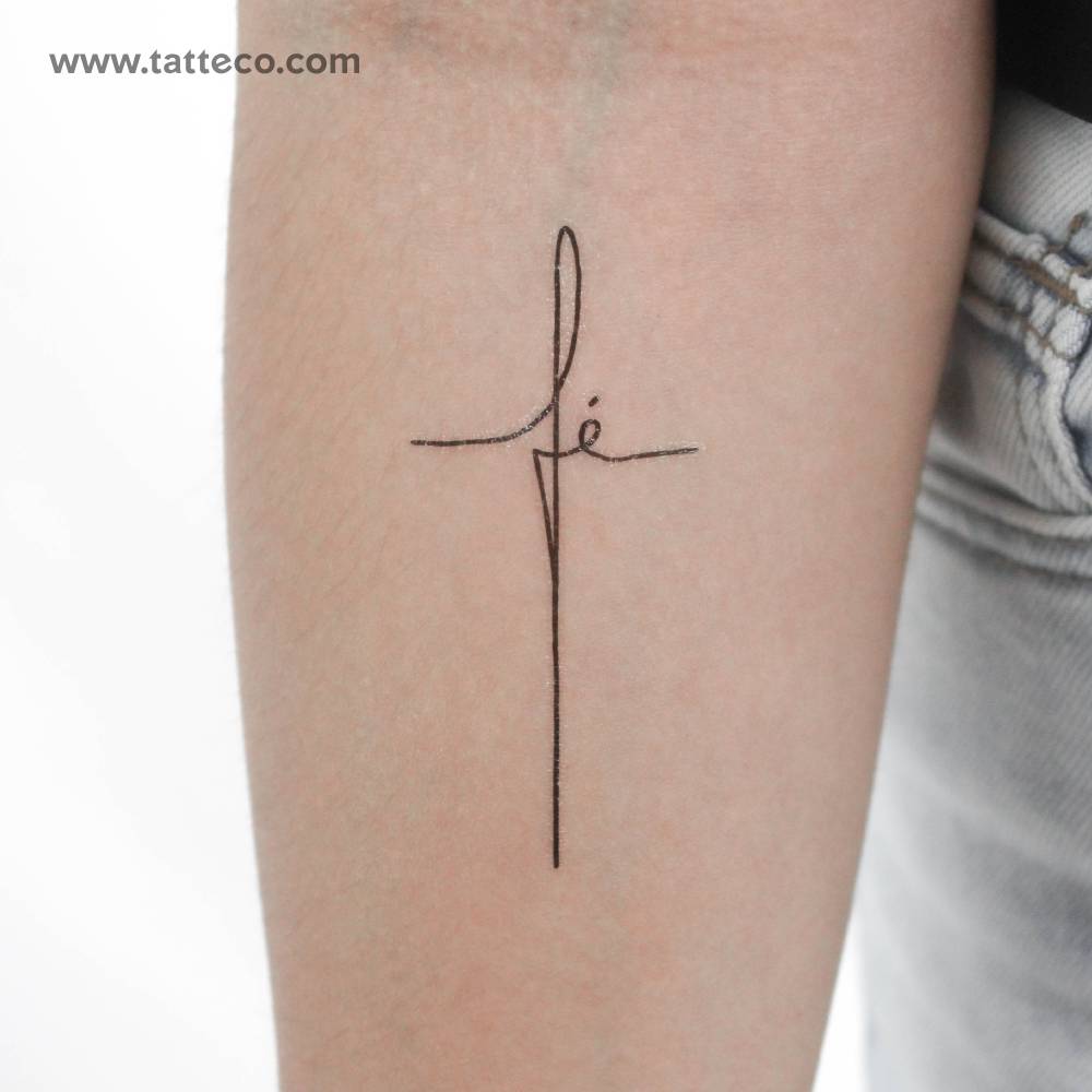 "Fé" cross temporary lettering tattoo located on the inner forearm.