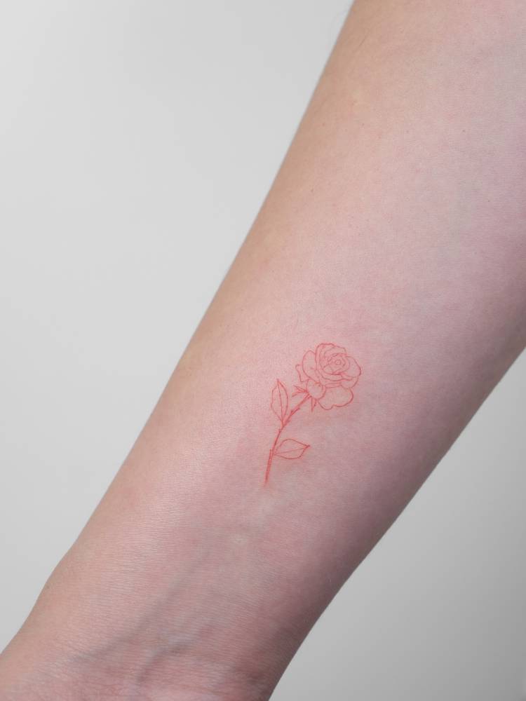 Red rose tattoo in fine line style done on the wrist.