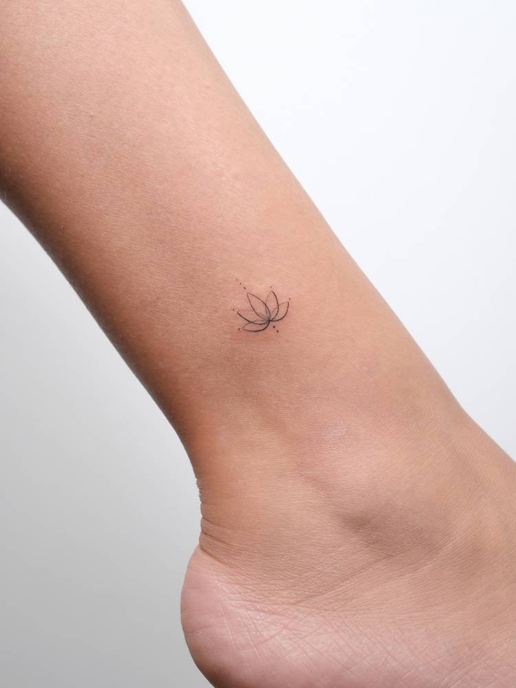 Little lotus flower tattoo located on the ankle, done in fine line style.