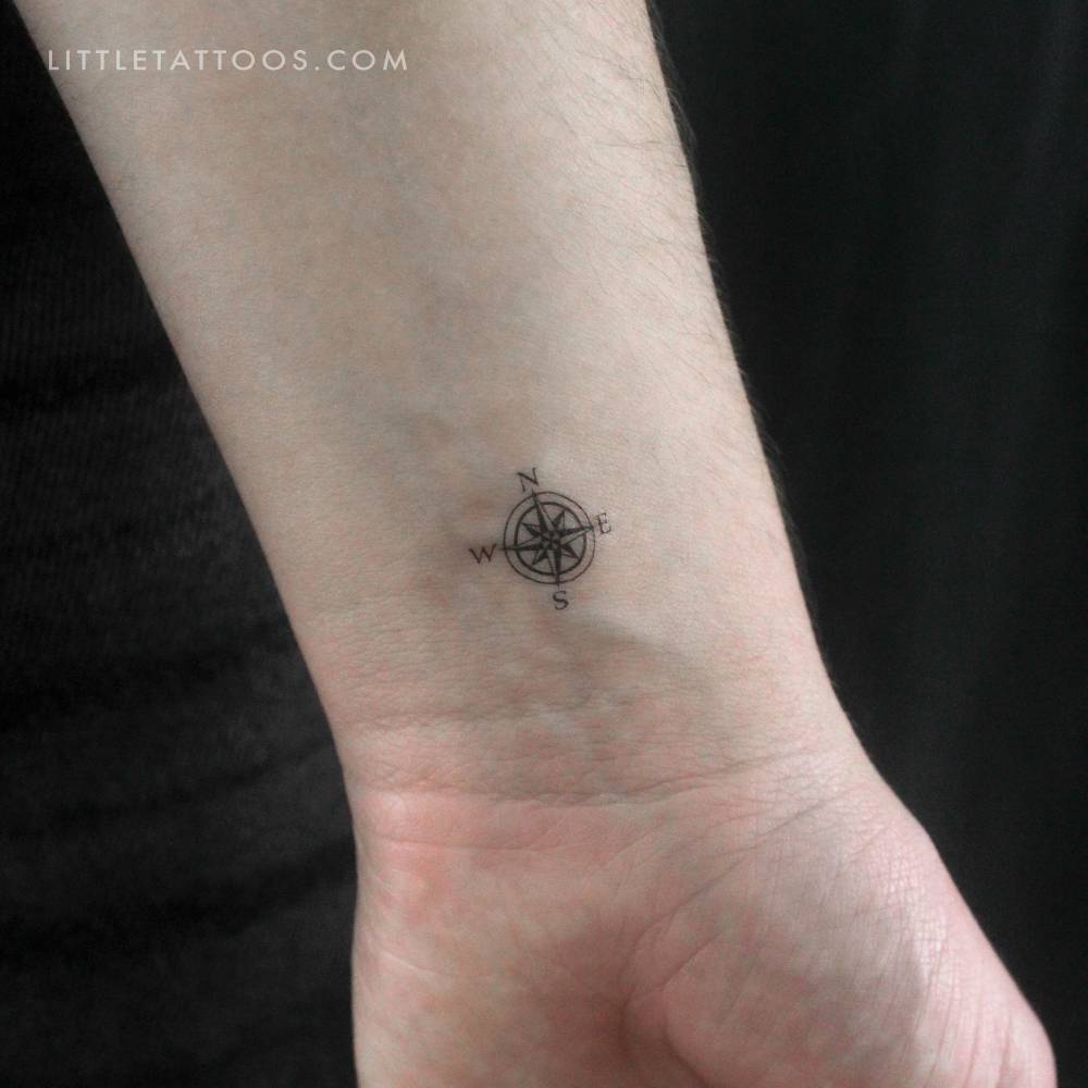 Tiny compass rose temporary tattoo located on the wrist.