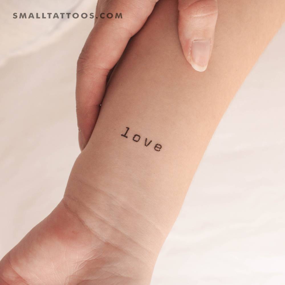 Typewriter font word 'love' temporary tattoo located on the wrist.