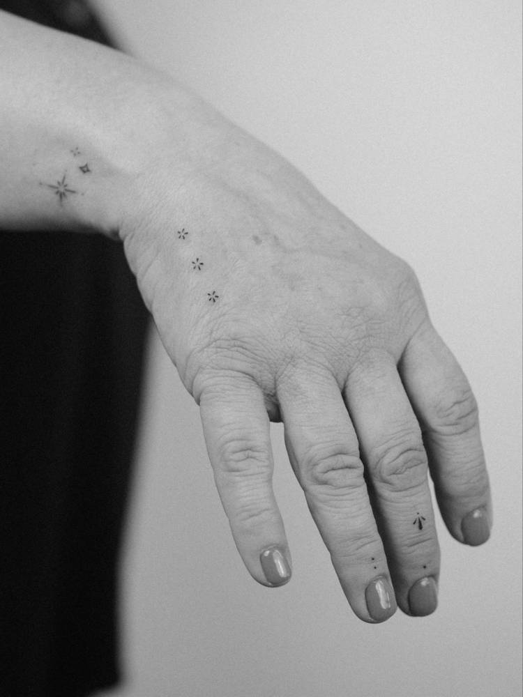 Flowers and ornaments tattooed on the hand and fingers.