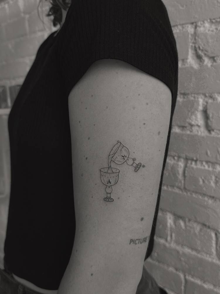 Chalices tattoo in fine line style placed on the upper arm.