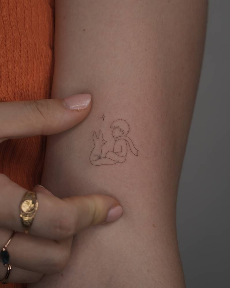 Single needle The Little Prince tattoo located on the bicep.