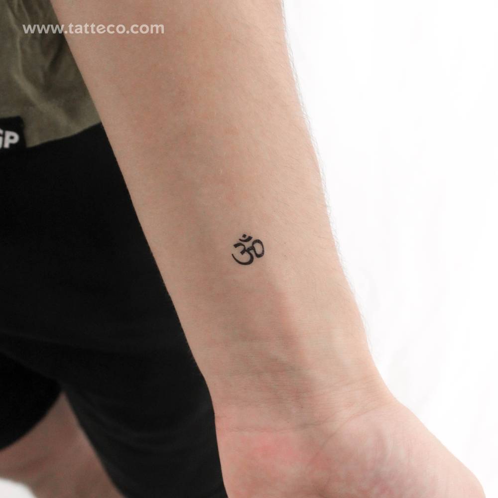 Tiny minimalistic Om temporary tattoo located on the wrist.