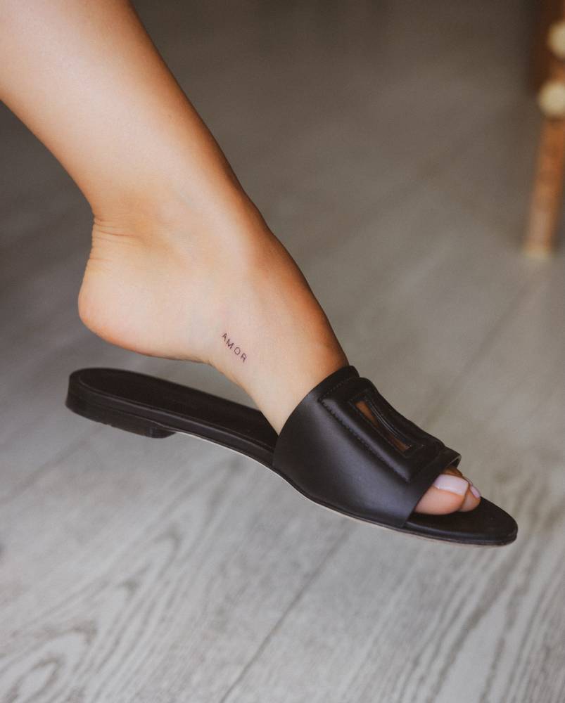 Little lettering tattoo of the word "amor" placed on the foot.