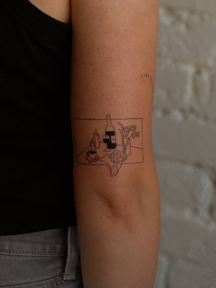 Fine line style still life tattoo placed on the tricep.