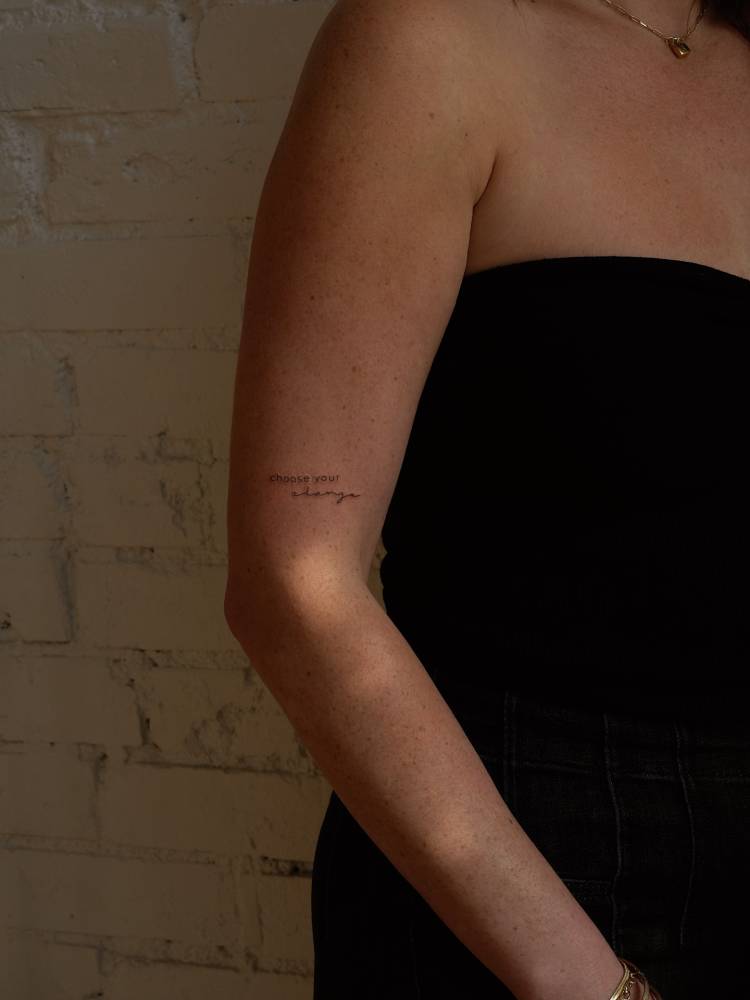 "Choose your change" lettering tattoo located on the upper arm.