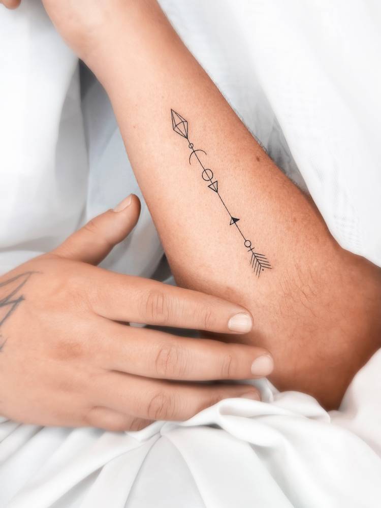 Arrow tattoo in fine line style placed on the forearm.
