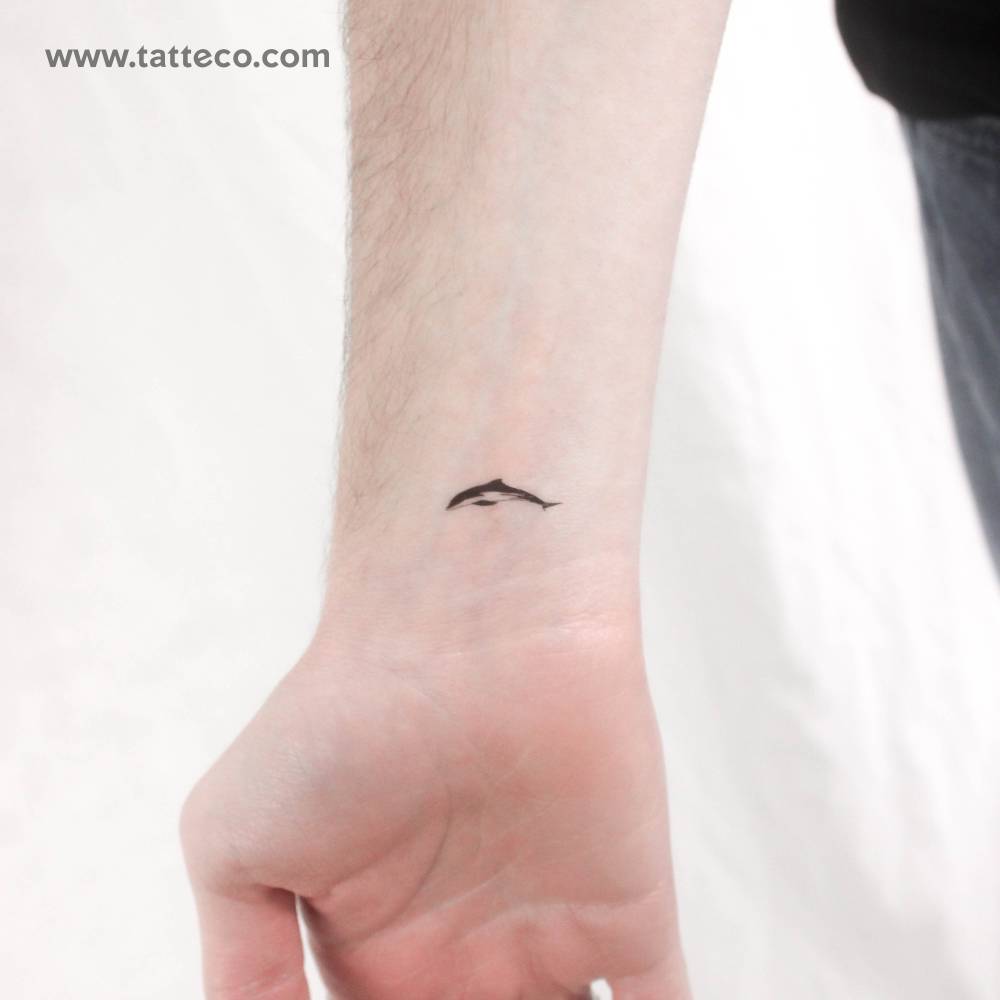 Little dolphin temporary tattoo located on the wrist.