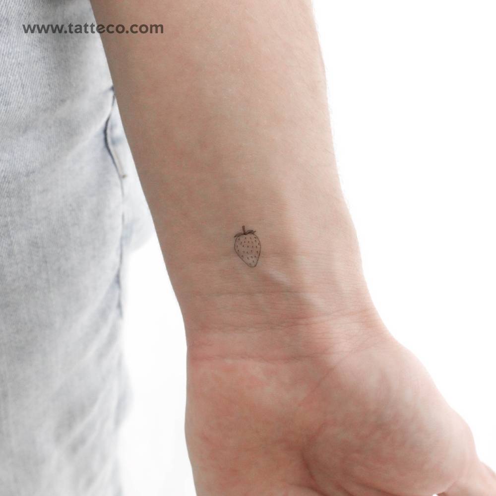 Little fine line strawberry temporary tattoo located on the wrist.