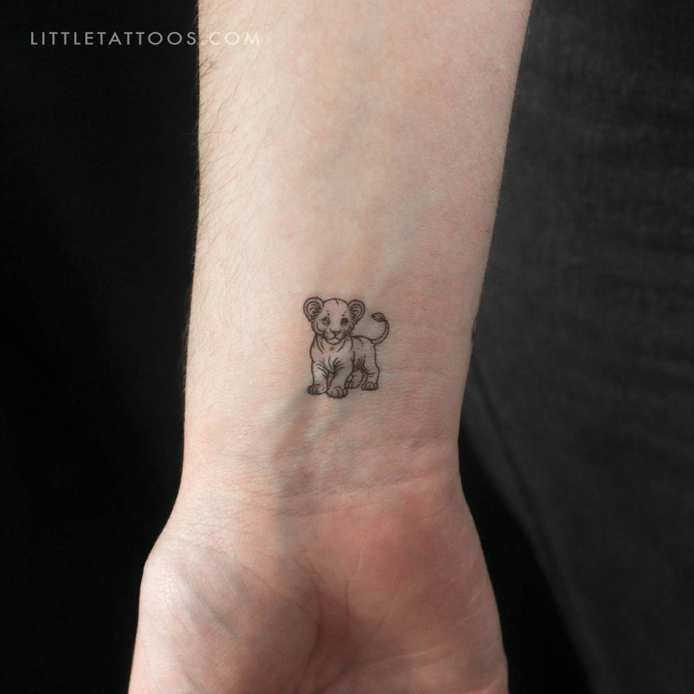 Little fine line style lion cub temporary tattoo located on the wrist.
