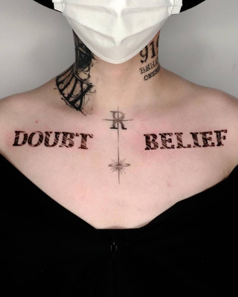 Words "doubt" and "belief" tattooed on the collarbones.