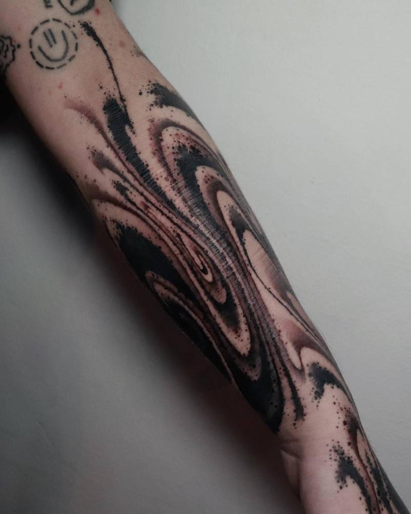 Abstract design tattoo in blackwork style located on the forearm.