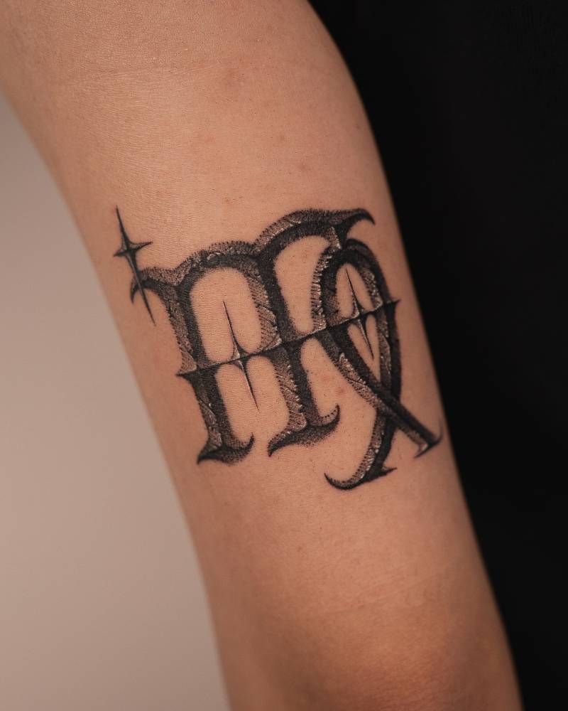 Virgo zodiac symbol tattoo located on the tricep.