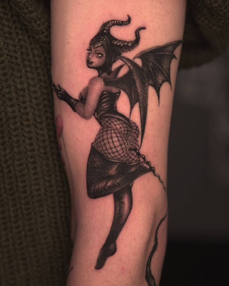 Maleficent tattoo in blackwork style located on the upper arm.