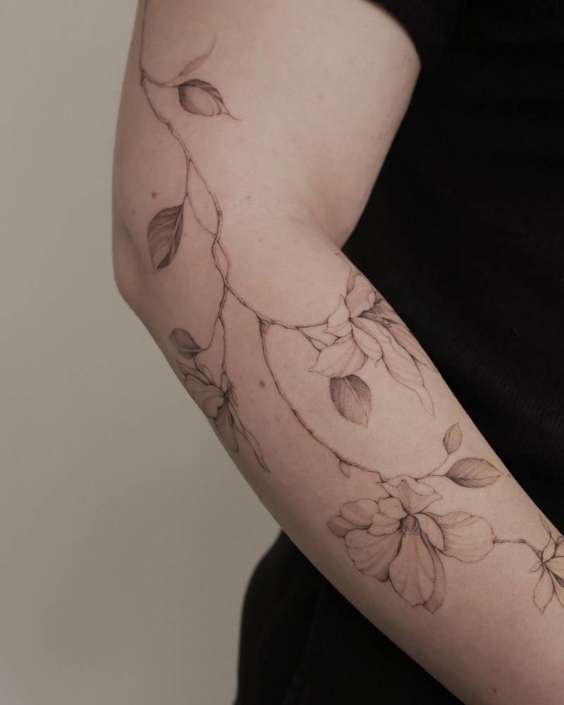 Magnolias tattoo placed on the arm, illustrative style.