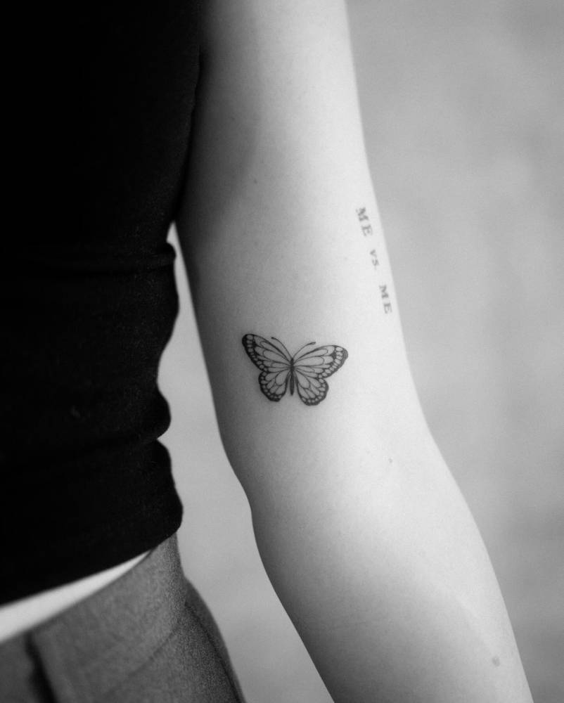 Illustrative style butterfly tattoo located on the inner arm.