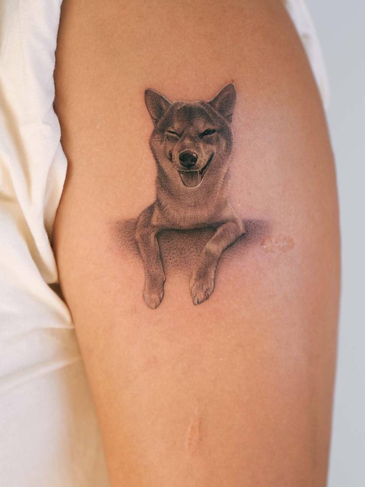 Shiba Inu tattoo in micro-realistic style located on the upper arm.