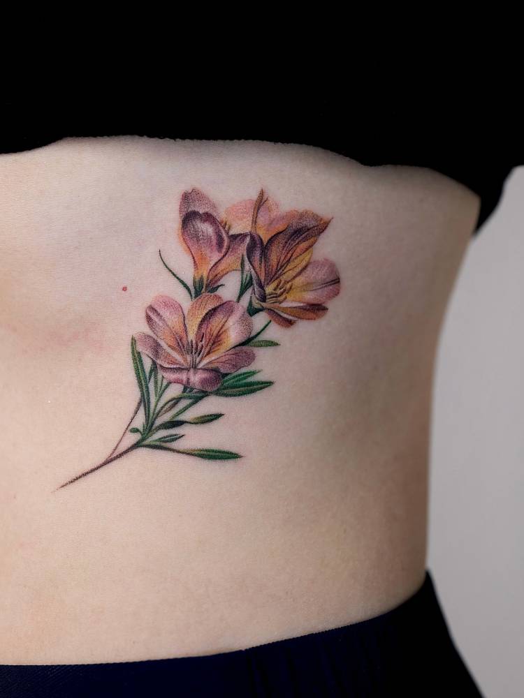 Lily of the incas tattoo located on the rib, done in micro-realistic style.