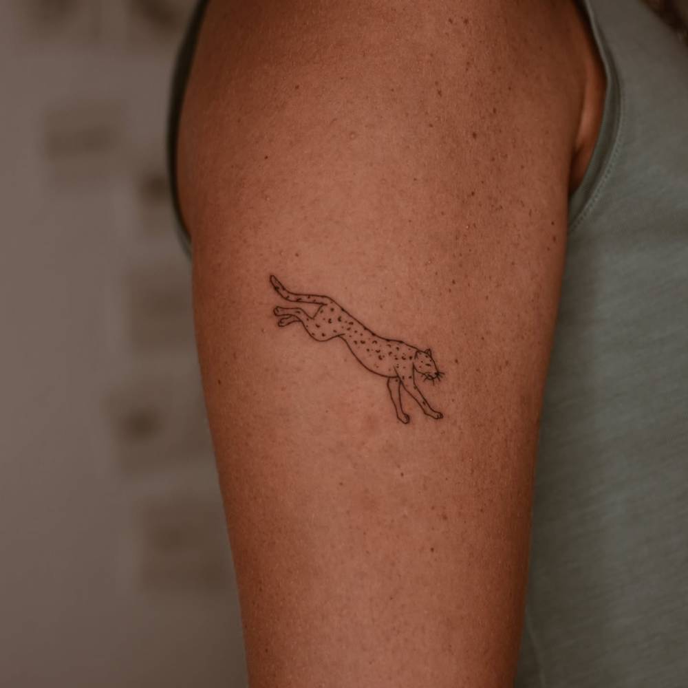 Little leopard tattoo located on the upper arm.