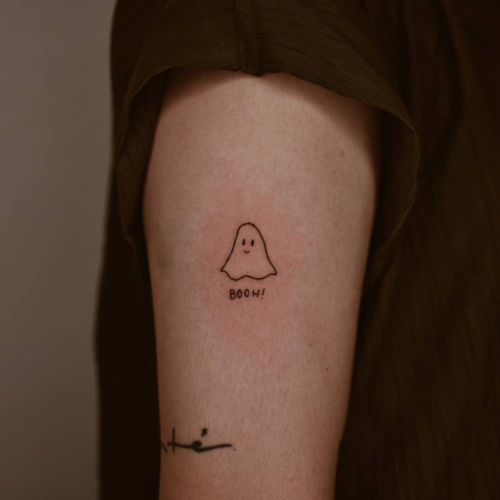 Little minimalistic ghost tattoo placed on the upper arm.