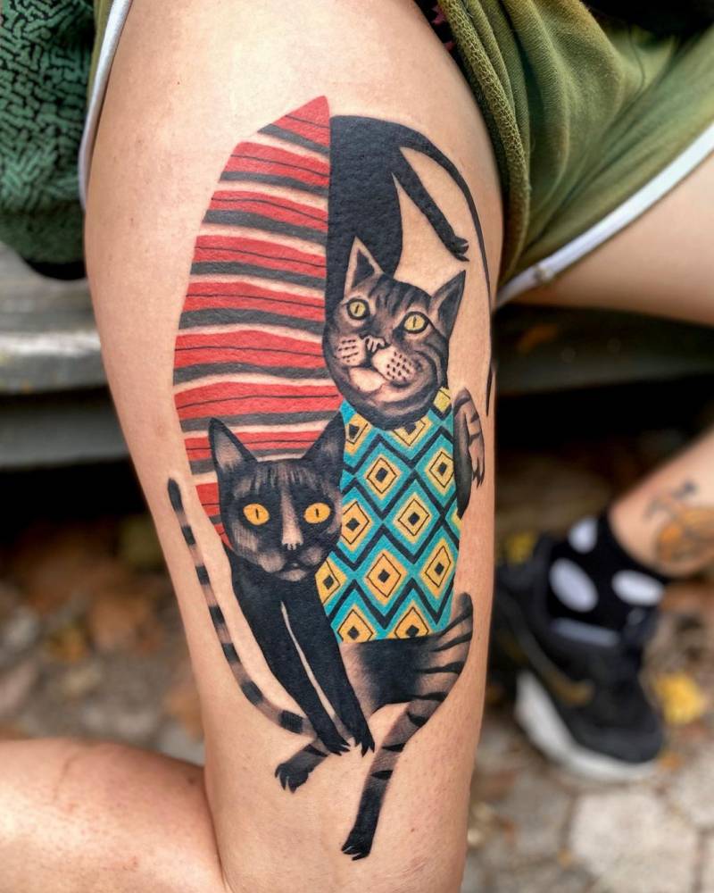 Cats tattoo located on the thigh.