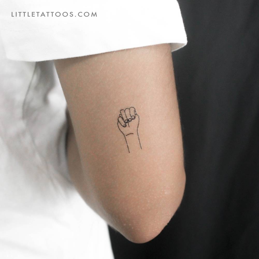 Fine line style sign language "M" temporary tattoo located on the tricep.