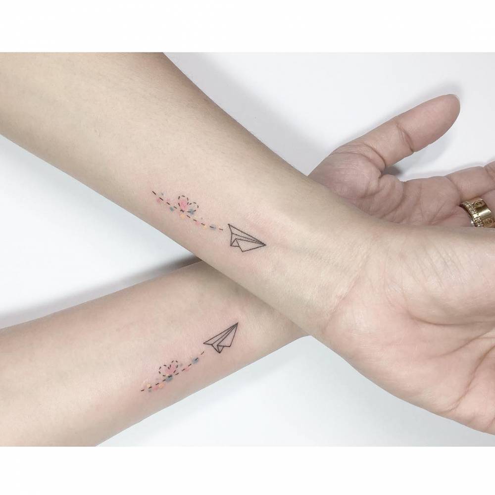 Matching paper plane and heart tattoo for best friends.