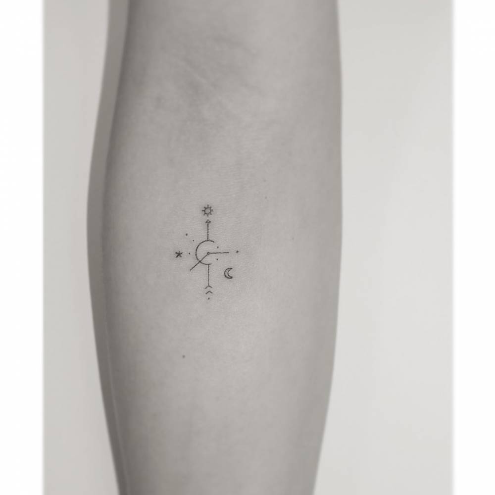 Compass rose tattoo in minimalistic style located on the inner forearm.