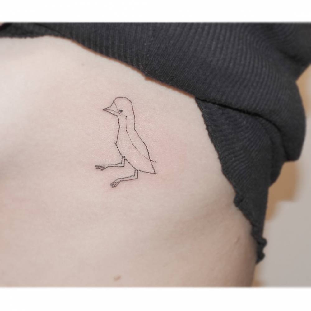 Bird tattoo in fine line style located on the rib.
